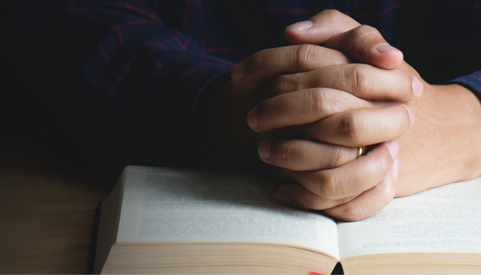 Hands resting on Bible